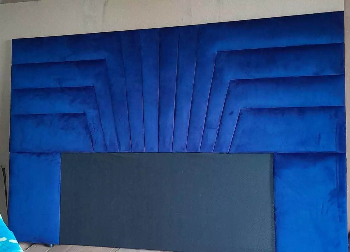 Geometric blue velvet upholstered headboard against a neutral wall