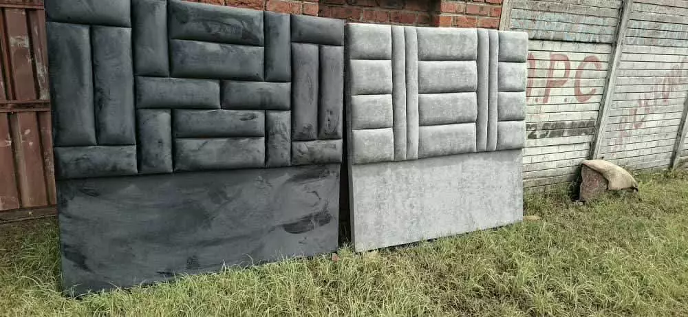 Two large upholstered headboards standing side by side outdoors