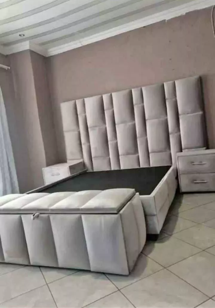 Upholstered bed with tall panel headboard and matching storage bench in a modern bedroom